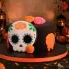Pastel de Día de Muertos en fondant negro con calaverita de azúcar tradicional y flores de cempasúchil en CDMX